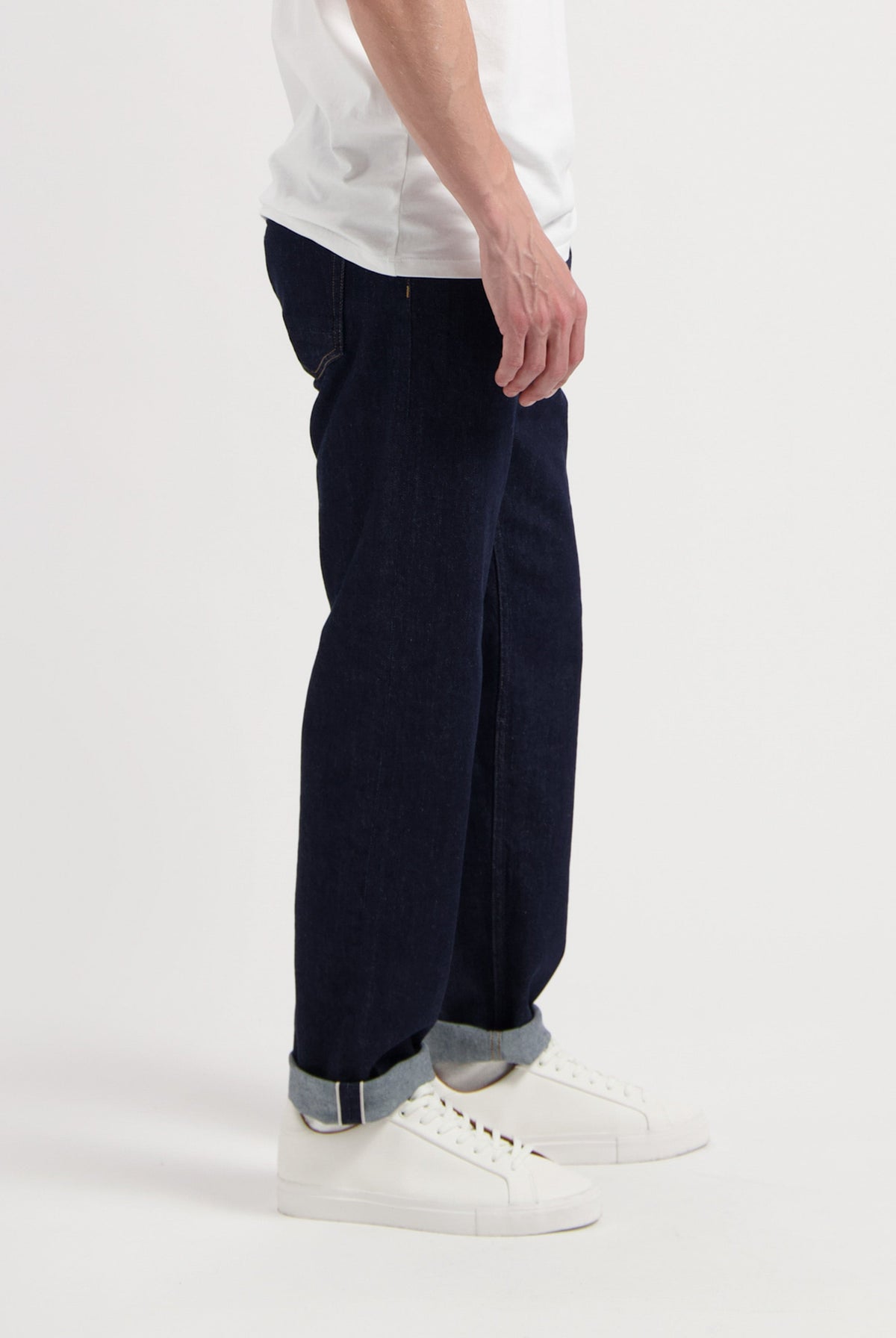 Sustainable MUD Jeans crafted from organic cotton, featuring dark blue denim in a regular fit, paired with a gray sweater.