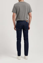 Sustainable MUD Jeans made from organic cotton, styled with a gray sweater, offering a timeless and ethical fashion choice.